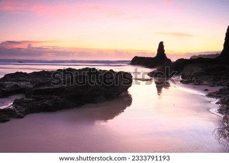 Beautiful sunrise skies and reflected colours in the tidal wet sands. Jones Beach, Kiama Downs Australia