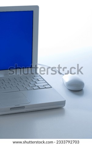 Laptop computer with blue screen and mouse.