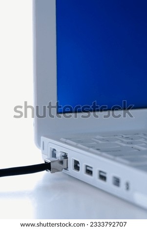 Close-up of data wire plugged into laptop computer.