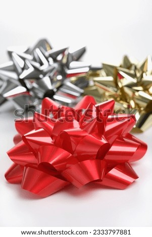 Still life of big shiny red, gold and silver Christmas bows.