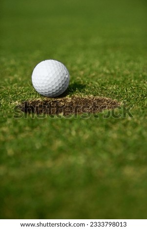 Close up image of golf ball close to the hole.