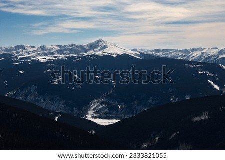Snow covered mountain peaks with valley in Colorado.