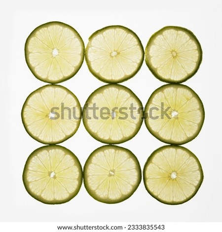 Lime slices arranged in square design on white background.
