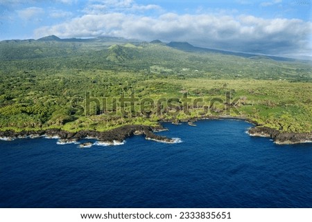 Aerial of Maui, Hawaii coastline with mountains in background.