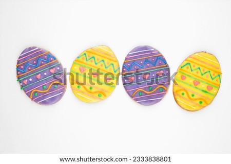 Four sugar cookies in shape of Easter eggs with decorative icing.