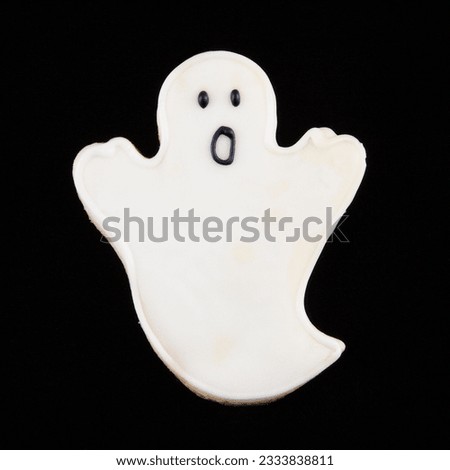 Sugar cookie in shape of a ghost with decorative icing.