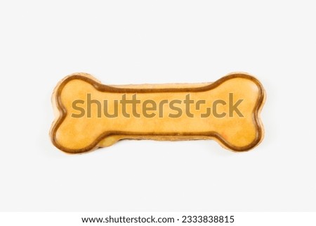 Sugar cookie in shape of dog bone with decorative icing.