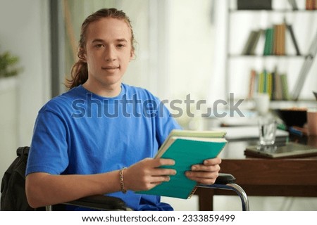 Portrait of high school student with disability studying in library Royalty-Free Stock Photo #2333859499