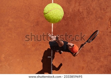 Top view of a professional tennis player serves the tennis ball on the court with precision and power Royalty-Free Stock Photo #2333859695