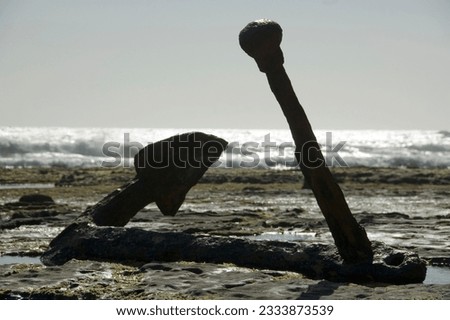 A large anchor from a 1800-s sailing ship that was shipwrecked on the rocks