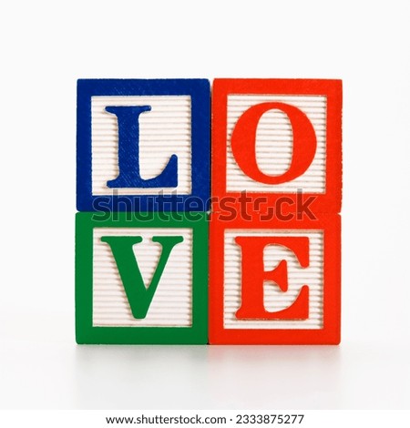 Stack of alphabet toy building blocks spelling the word love.