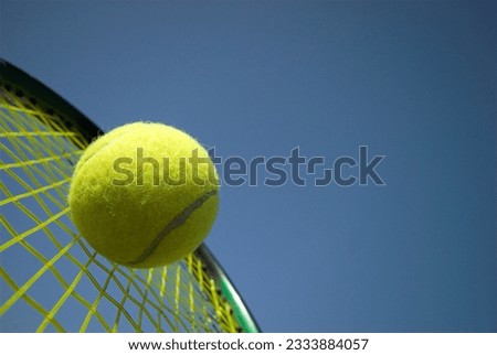 Tennis racket and yellow tennis ball sky blue
