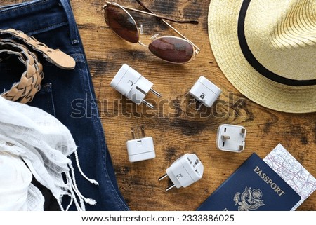 Travel essentials flat lay including power converter, voltage travel adapter 220v 110v Packing converters adapters for trips vacation in Europe UK Australia or North America - World traveler selection Royalty-Free Stock Photo #2333886025