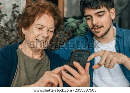 young man teaching grandfather mobile phone Royalty-Free Stock Photo #2333887503