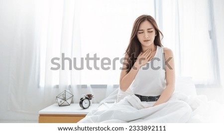 Young pretty asian woman hand on her throat having runny nose. Portrait of Asian beautiful girl get sick sneezing from flu. Healthcare and medical, allergy syndrome, stressful sore throat concept. Royalty-Free Stock Photo #2333892111