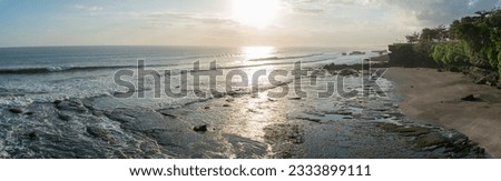 View of the coral beach skyline with waves chasing under the bright afternoon sun at Tanah Lot Beach Bali Indonesia, Bali Tourism
