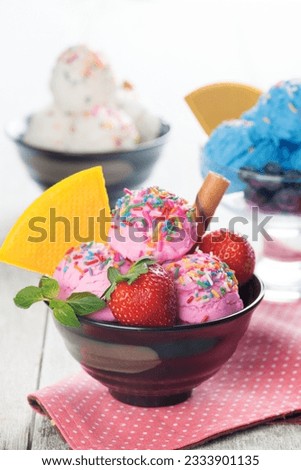 Strawberry, blueberry and vanilla ice cream in bowl on white rustic wooden background.