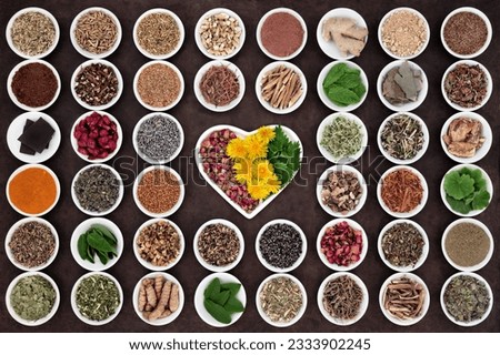 Herbal medicine selection used for womans health in heart and round shaped porcelain bowls over lokta paper background.