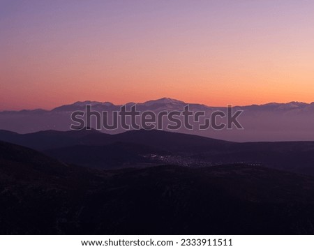 Mountain range covered in snow in dusk colors, Greece