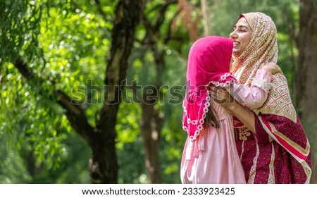 Portrait of happy religious enjoy happy love asian islam family muslim mother and little muslim girls child with hijab dress smiling and having fun moments good time, islam, ramadan in summer park