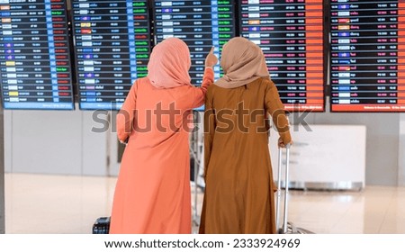 Young friend muslim woman traveler with luggage look flight travel before long travel vacation flight at International terminal airport