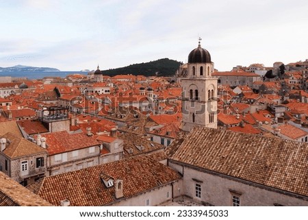 High angle view of the red  tiles and building roofs in the Old Town of Dubrovnik in Croatia, with the top of its landmark bell tower clearly visible. Photo taken from the top of the city wall.