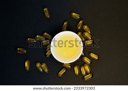 Fish oil in clear yellow capsules. for dietary supplement isolate black background