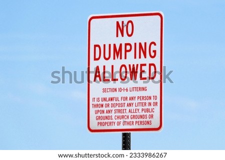 no dumpoing or littering allowed - city sign on post against blue sky