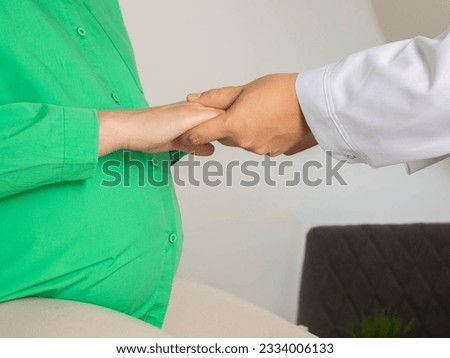 The hands of a psychologist doctor hold the hands of a pregnant woman. The concept of psychological balance. Psychology of pregnancy and motherhood. Royalty-Free Stock Photo #2334006133