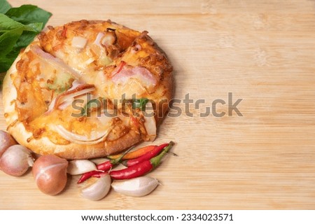 Pizza on wooden board with fresh peppers and basil with garlic on copy space background for text on various important occasions