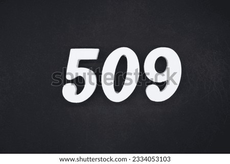 Black for the background. The number 509 is made of white painted wood.