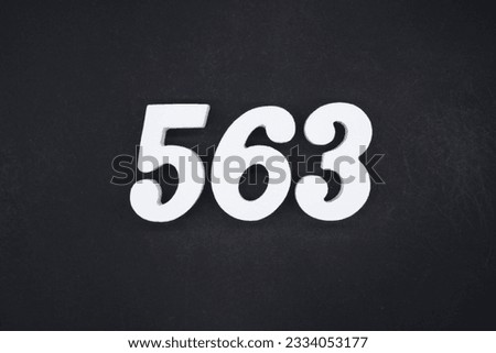Black for the background. The number 563 is made of white painted wood.