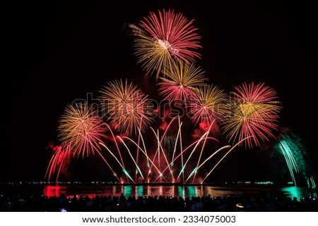 PATTAYA, CHONBURI, THAILAND Beautiful colorful fireworks night scene at Pattaya International Fireworks Festival and silhouette Group of tourist take pictures of firework show on the beach,
