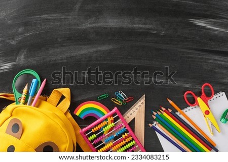 Embrace fresh start of the school year with this captivating high-angle picture displaying child backpack and collection of school supplies on blackboard backdrop, copy-space invites text or promotion
