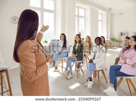 Business school coach gives workshop master class to multiracial multiethnic adult female audience, presents new course, talks to women, answers questions about career development. Education concept Royalty-Free Stock Photo #2334099267