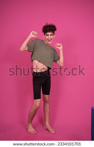 Fitness and retro style. Funny drag queen goes in for sports in the studio on a pink background.