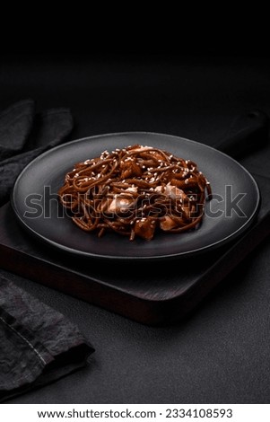 Delicious fresh buckwheat noodles with boiled tiger prawns, salt, spices and mushrooms on a dark concrete background