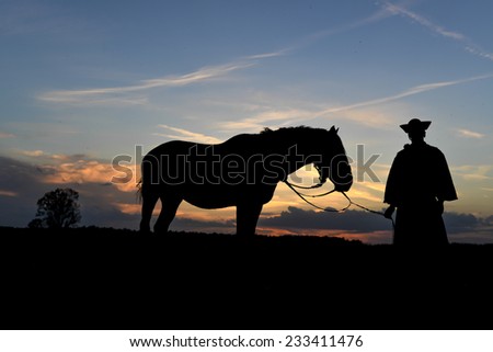 Hungaryan wrangler whith his horse,on sunset