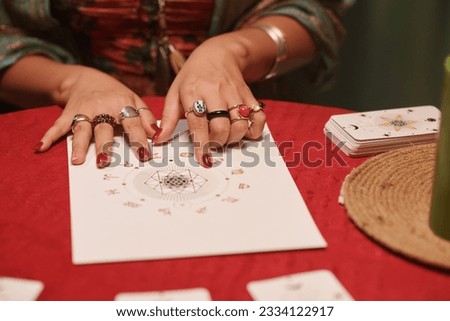 Closeup image of astrologer examining natal chart of client to check love compatibility of her and her partner Royalty-Free Stock Photo #2334122917