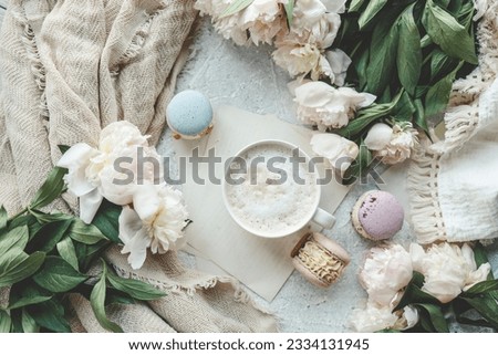 Cup of coffee, sweet macaroons and white peonies, beautiful aesthetic photo.