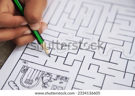 kid hand with pencil doing maze line game for learning and practise brain using in learning idea