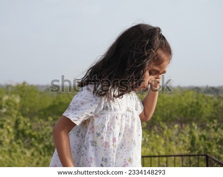 Wonderful photo filter effect on portrait sunset cute little girl image. Natural blur background and clear focus. Dark mode of adventure scenery. Different close up hand style wearing black.