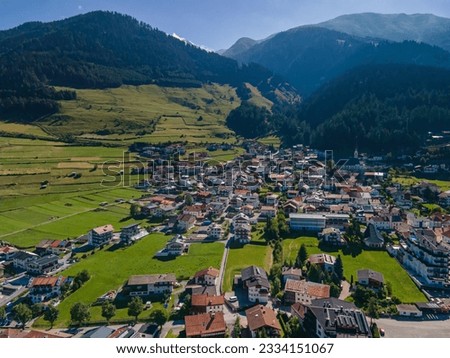 South Tirol village embedded in green mountain landscape from top