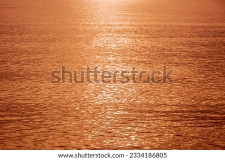 Abstract photo of surface water of lake at sunset time with golden light tone.