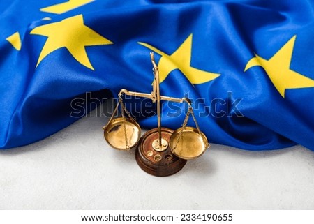 Scales of justice and flag of European Union on white table