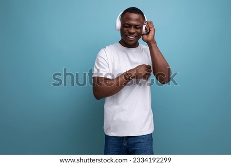 30 year old American male adult in white t-shirt enjoys listening to favorite music with headphones