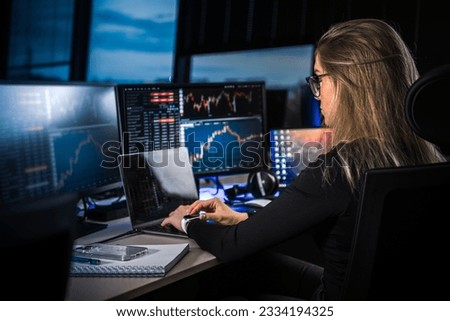 Cryptocurrency stock market female trader. Cryptocurrency professional trader. Night work. Working late. Computer screens.