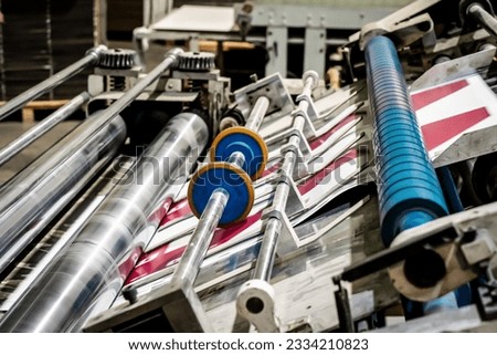Printing at high speed on offset machine. Label, Rolled Up, Printing Out, Group of Objects Merchandise Royalty-Free Stock Photo #2334210823
