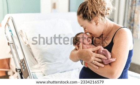 A New born baby boy resting in mothers arms. Royalty-Free Stock Photo #2334216579
