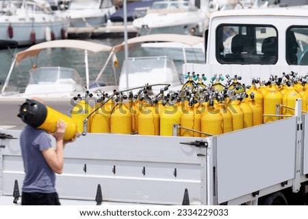 scuba tanks of diving center with air nitrox or trimix in marina port  for courses or dive trips Royalty-Free Stock Photo #2334229033